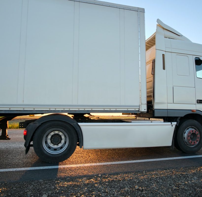 semi-truck-with-cargo-trailer-driving-on-highway-hauling-goods-in-evening-delivery-transportation.jpg